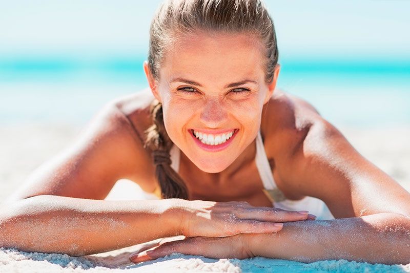 Centro Dental Burjassot mujer sonriendo en la playa